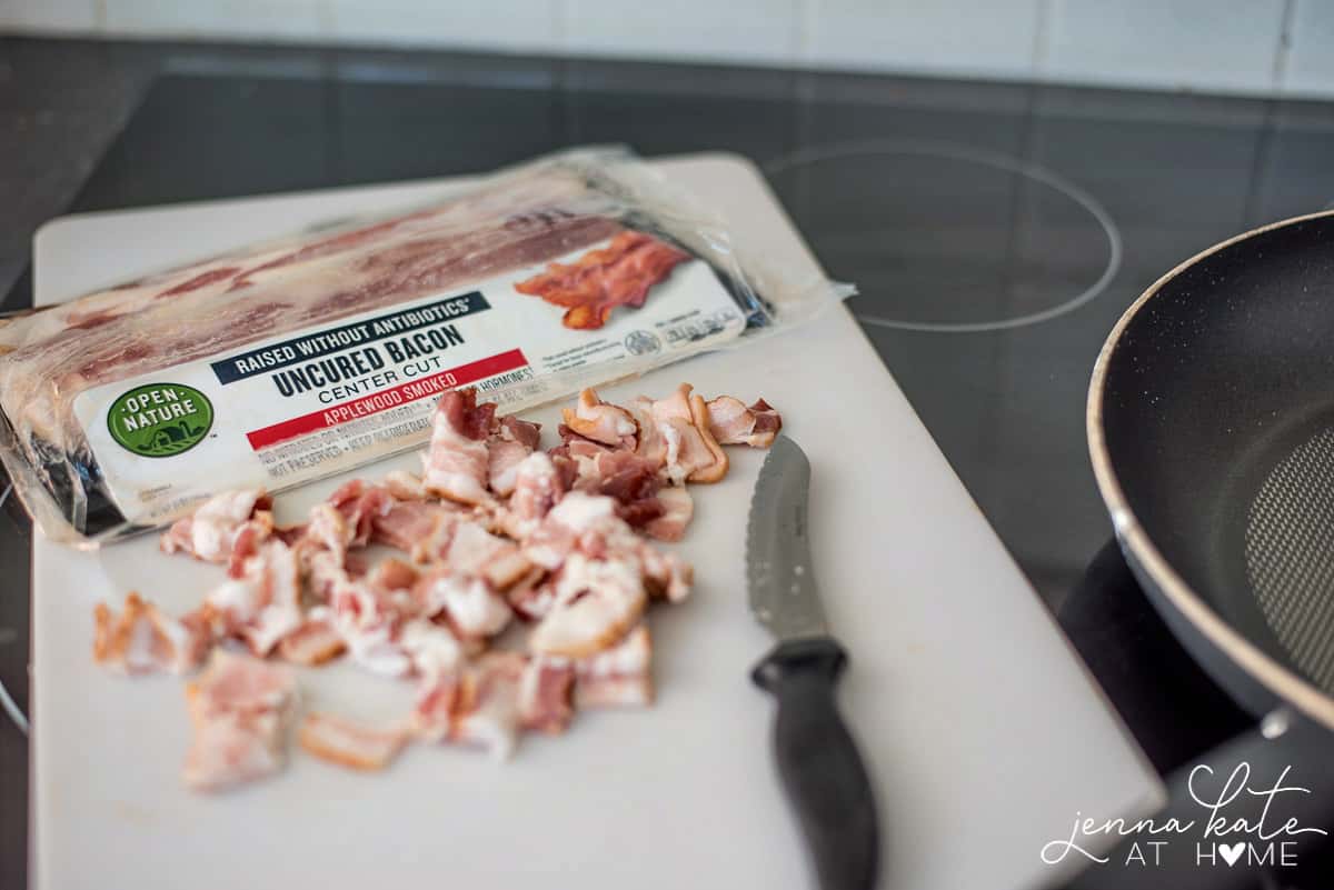 An opened package of uncured bacon and chopped pieces of bacon on a white cutting board