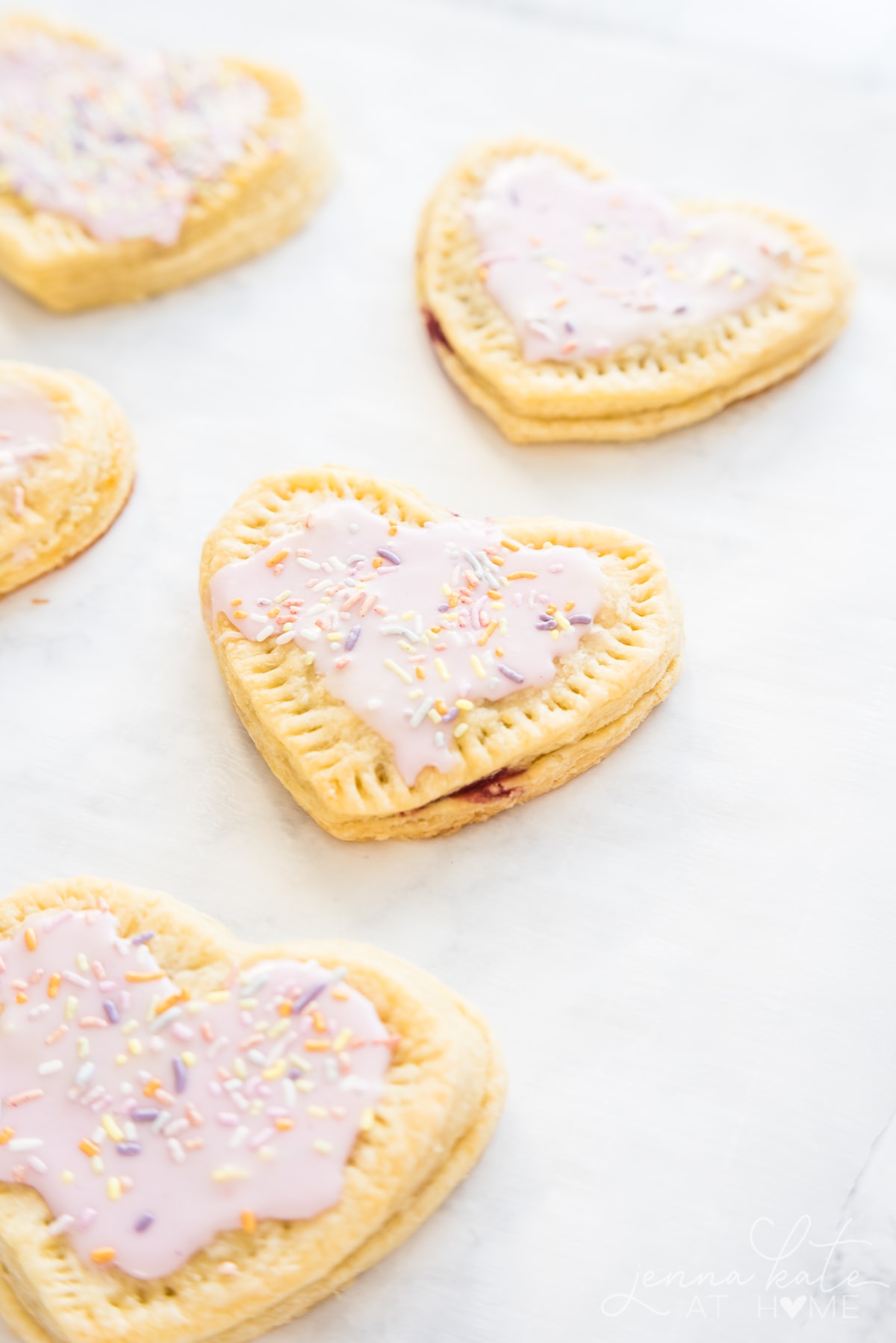 baking sheet full of decorated homemade strawberry pop tarts for Valentines day