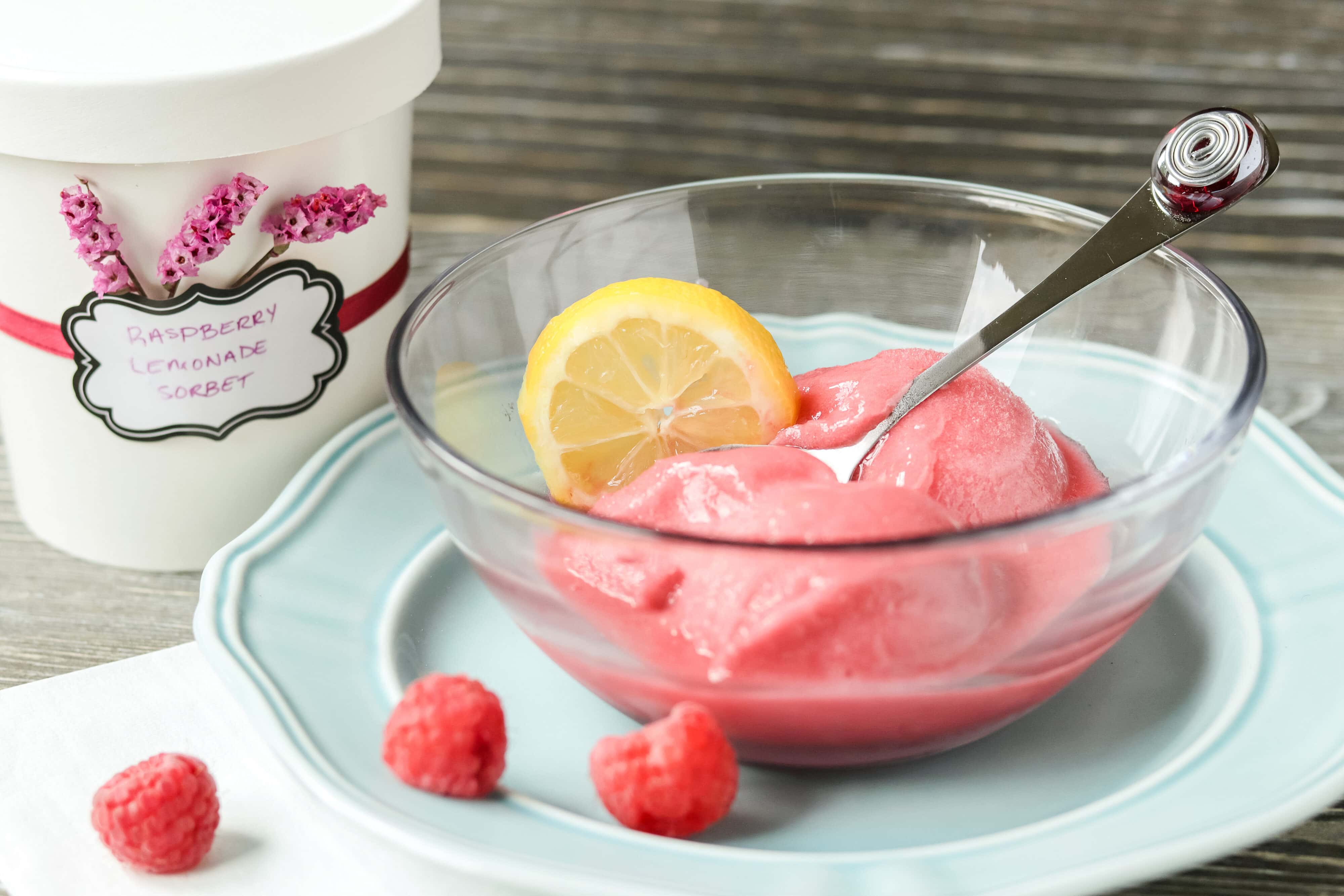 sorbet in a bowl with lemon and raspberries