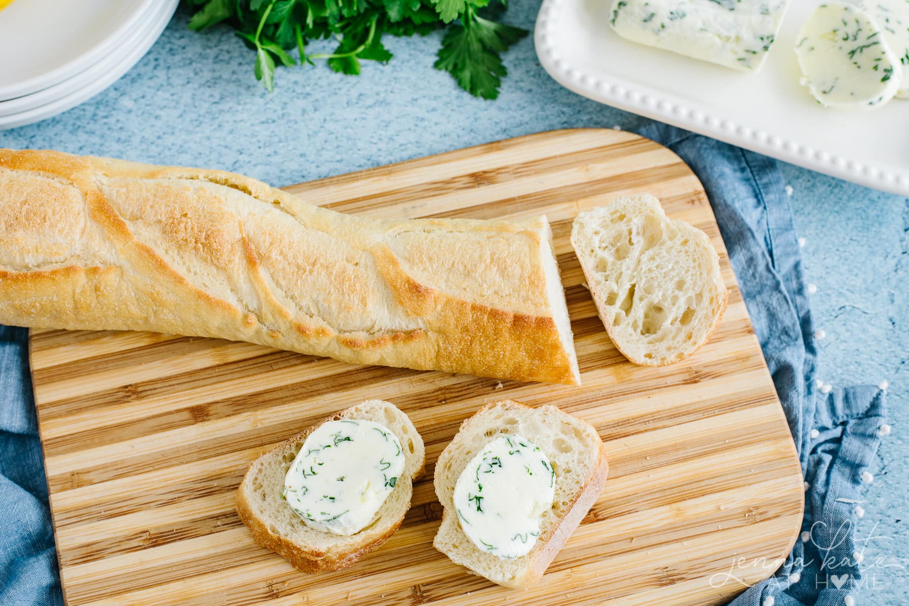 sliced baguette with pats of garlic herb butter 