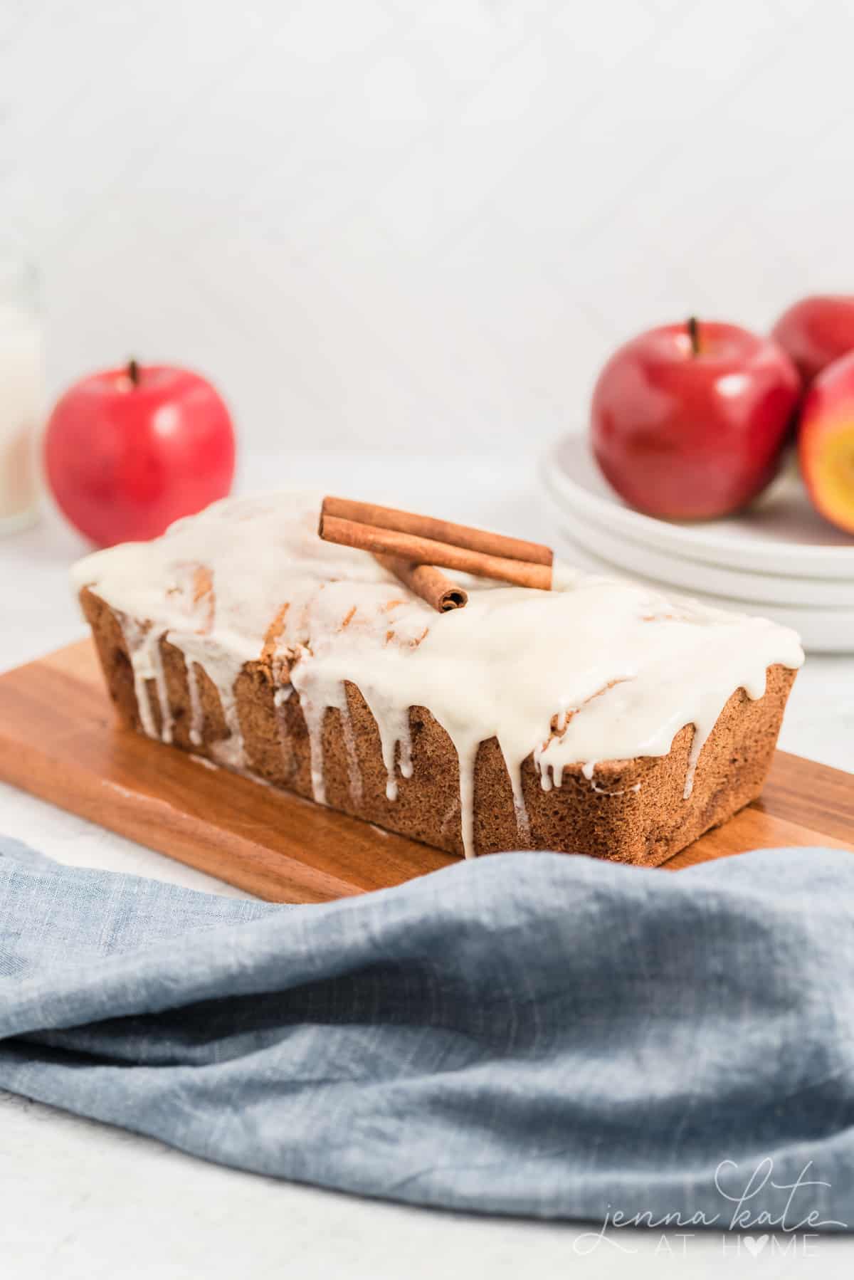 Cinnamon apple quick bread loaf with vanilla glaze and cinnamon sticks on top