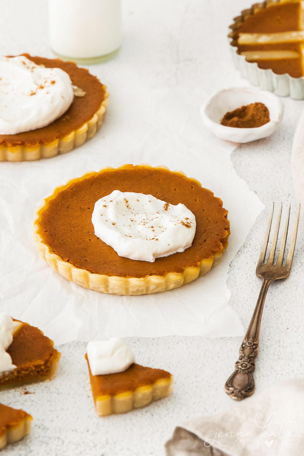 several mini pumpkin pie tarts with whipped cream on top