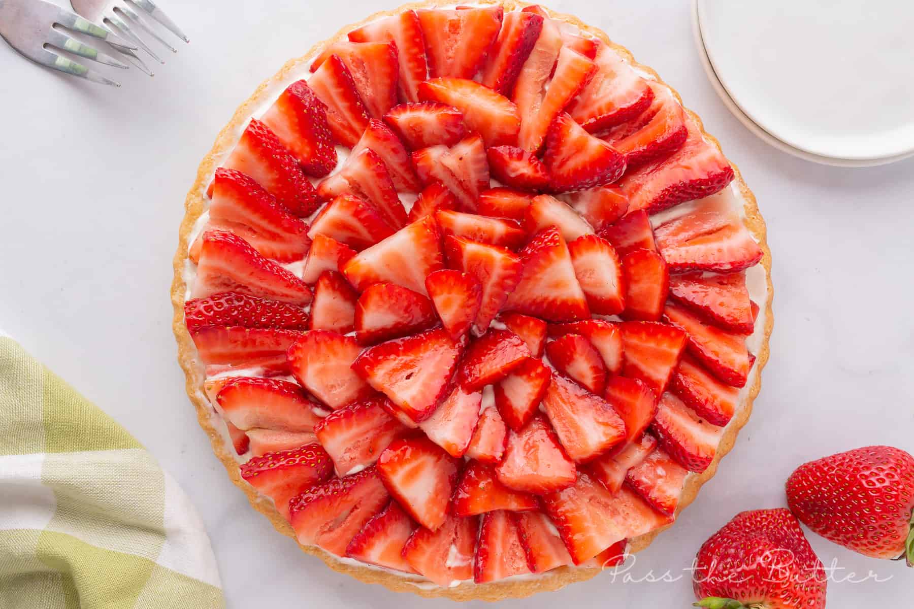 Strawberry flan on counter with fresh strawberries and plates